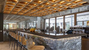A modern bar area with a stone countertop, bar stools, and a wooden ceiling. - Pleasant Apartment Near Ehrwald Town (Ehrwald)