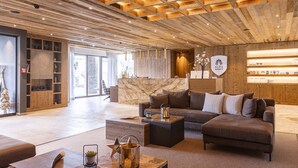 A modern lobby with a wooden ceiling, a marble reception desk, and a seating area with sofas and a coffee table. - Pleasant Apartment Near Ehrwald Town (Ehrwald)