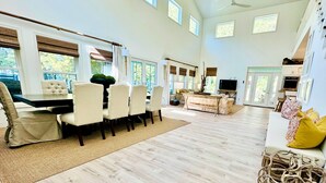 Un salón amplio con una mesa de comedor, sillas, un sofá y un televisor.