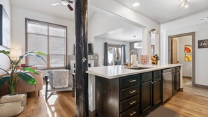 A modern kitchen with dark cabinetry, a white countertop, and a large island. - Perfectly Located 3 Bed 3.5 Bath Beautiful Townhome (Edwards)