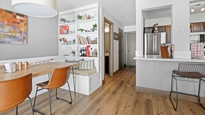 A modern kitchen with white cabinetry, a wooden dining table, and a built-in bench. - Perfectly Located 3 Bed 3.5 Bath Beautiful Townhome (Edwards)