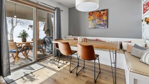 A modern dining area with a wooden table and chairs, a pendant light, and a colorful abstract painting on the wall. - Perfectly Located 3 Bed 3.5 Bath Beautiful Townhome (Edwards)
