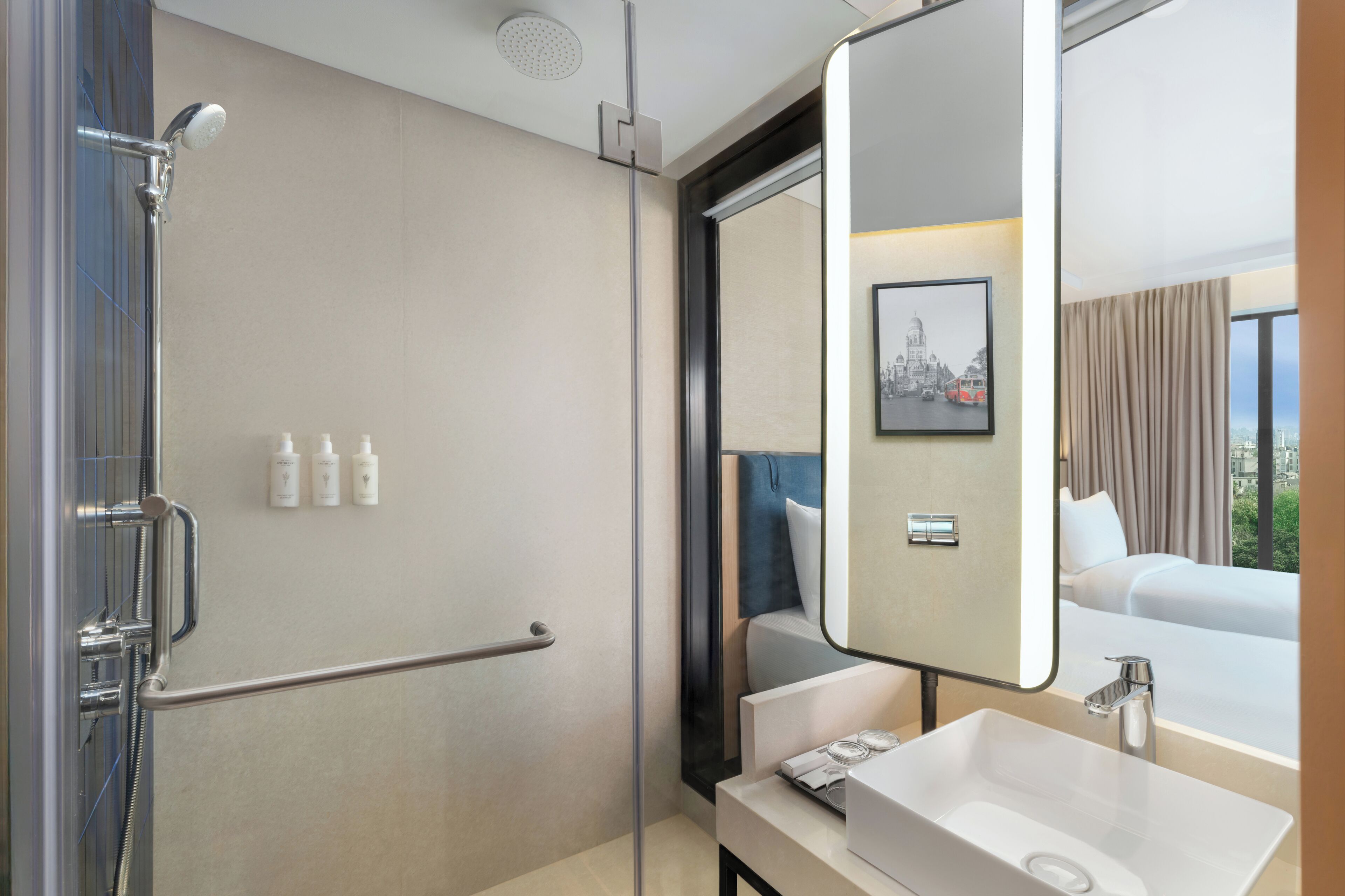 Een moderne badkamer met een inloopdouche, een grote spiegel en een wastafel.