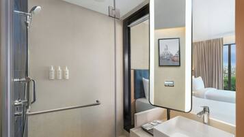 Een moderne badkamer met een inloopdouche, een grote spiegel en een wastafel.