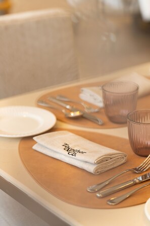 A neatly set table with a folded napkin, a plate, cutlery, and a glass. - Hilton Garden Inn Mumbai International Airport (Mumbai)