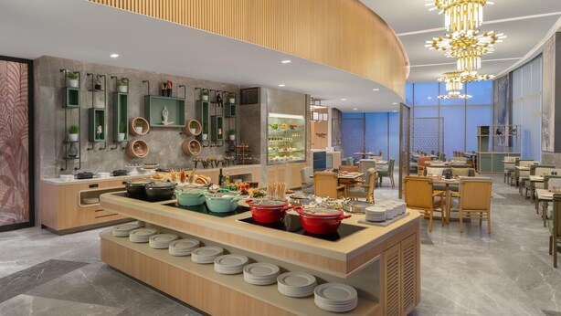 Uma sala de jantar moderna com serviço de buffet, detalhes em madeira e um lustre contemporâneo.