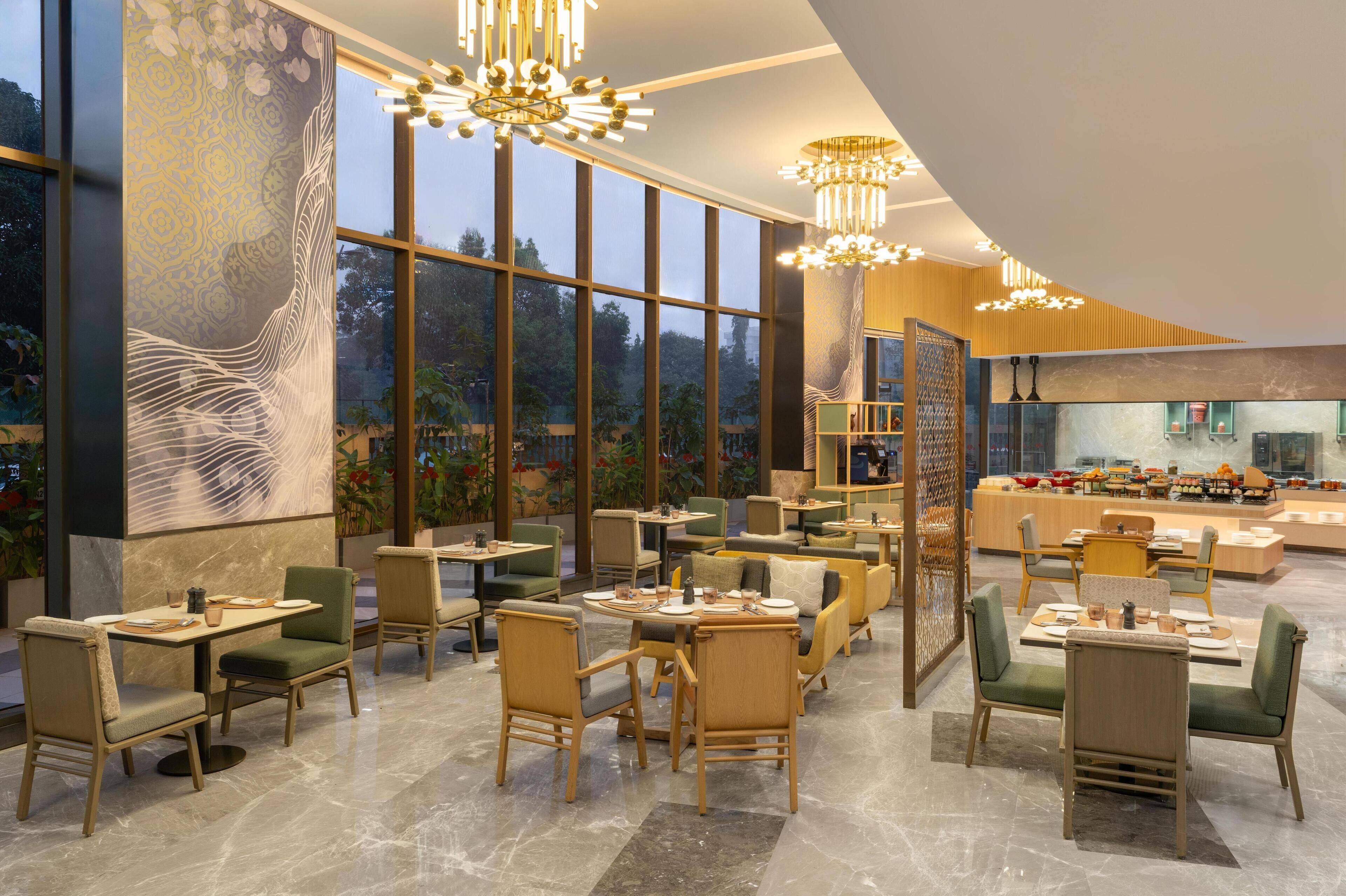 A modern restaurant with high ceilings, large windows, and a variety of seating arrangements.