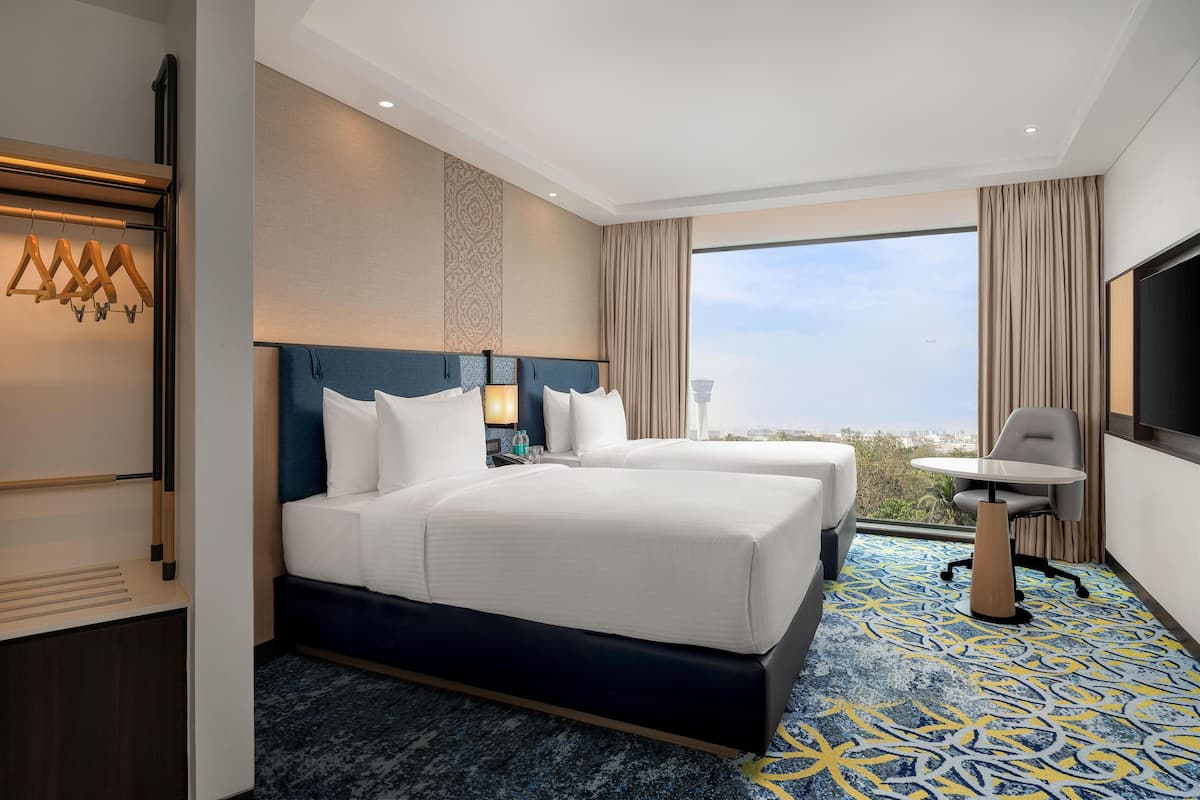 Deluxe Room, 2 Twin Beds (Runway View) | Minibar, desk, laptop workspace, free cribs/infant beds