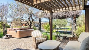 An outdoor patio with a hot tub, wicker furniture, and a pergola. - Beaufiul Sonoma house on large property in vineyards with lots of amenities! (Sonoma)