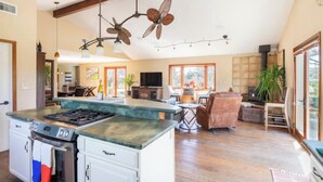 A spacious kitchen with a central island, a dining area with a table and chairs, a fireplace, and a ceiling fan. - Beaufiul Sonoma house on large property in vineyards with lots of amenities! (Sonoma)