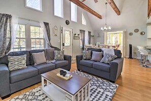 A spacious living room with two grey sofas, a wooden coffee table, and a dining area with a table and chairs. - Charming 3-bedroom Poconos Family Getaway in Albrightsville PA (Albrightsville)