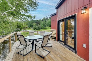 Une terrasse avec une table et des chaises, donnant sur un paysage naturel.