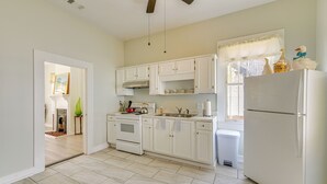 A kitchen with white cabinets, a stove, and a refrigerator. - Walk to Riverfront Park: Updated Home in Columbus! (Columbus)