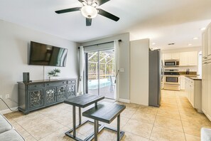 Enjoy meals in the kitchen with a central island, dining area, and large window overlooking the backyard pool.