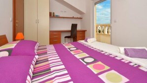 A bedroom with a bed, a desk, and a chair. There is a window with a view of buildings. - Bright Kaštela Apartment With Balcony and Private Parking (Kastela)