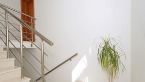 A staircase with metal railings, a potted plant, and a wooden door. - Bright Kaštela Apartment With Balcony and Private Parking (Kastela)