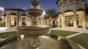 A fountain in a courtyard with a building in the background.