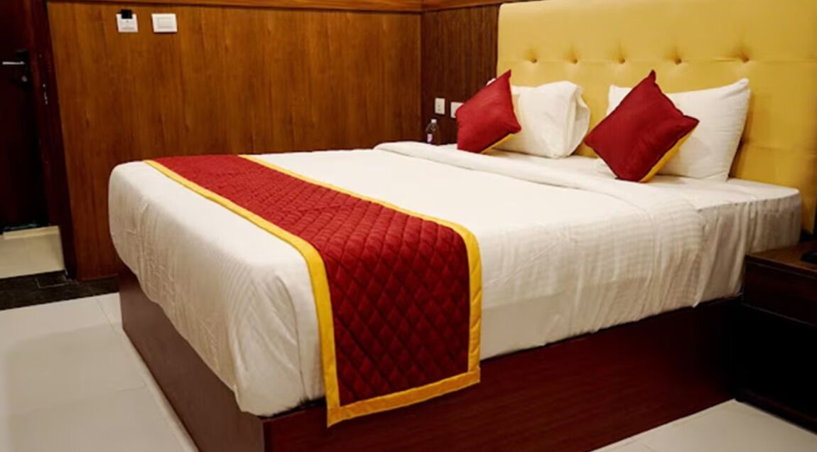 Ein Hotelzimmer mit einem großen Bett, Holzvertäfelung an den Wänden und einem gelben Kopfteil.