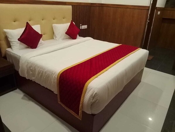 A neatly made bed with a red and white bedspread and matching pillows.