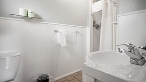 Ein Badezimmer mit Toilette, Waschbecken und Duschbereich.