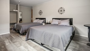 Ein Hotelzimmer mit zwei Betten, einem kleinen Tisch und einem Kleiderschrank.