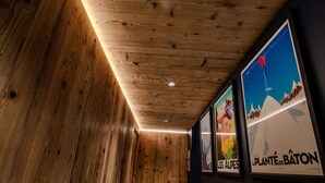 Un couloir intérieur aux murs en bois, orné d’affiches encadrées.