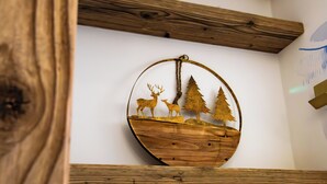 Un élément de décoration murale en bois, de forme circulaire, représentant un cerf et des arbres.