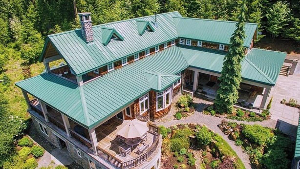A large, multi-story house with a green roof, multiple balconies, and a landscaped garden. - Trout Lake Treehouse - A large, splendid, and private mountain home! (Trout Lake)