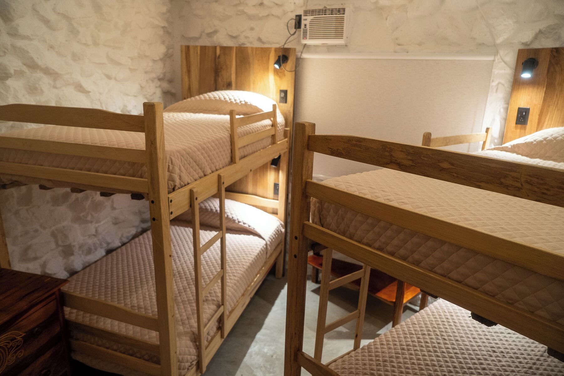 A bunk bed room with wooden frames and white bedding.