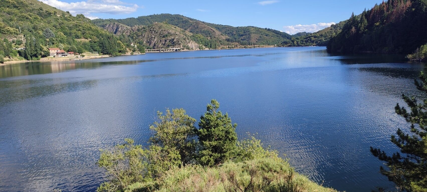 Un lago tranquillo circondato da colline e alberi.