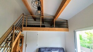 A room with a bunk bed, a wooden staircase, and a large window. - L'Echappée du Camboux.  
Wellness discounts (Sainte-Cécile-d'Andorge)