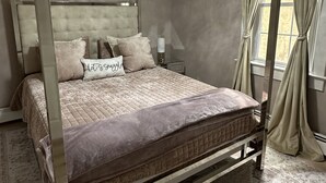 A four-poster canopy bed with a tufted headboard, a chandelier, and a view of the outdoors through a window with curtains. - Private Cozy 2-bedroom apartment in charming Scranton with AC (Scranton)