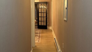 A hallway with wooden flooring, beige walls, and a door at the end. - Private Cozy 2-bedroom apartment in charming Scranton with AC (Scranton)