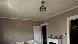 A living room with a sectional sofa, a fireplace, and a chandelier. - Private Cozy 2-bedroom apartment in charming Scranton with AC (Scranton)