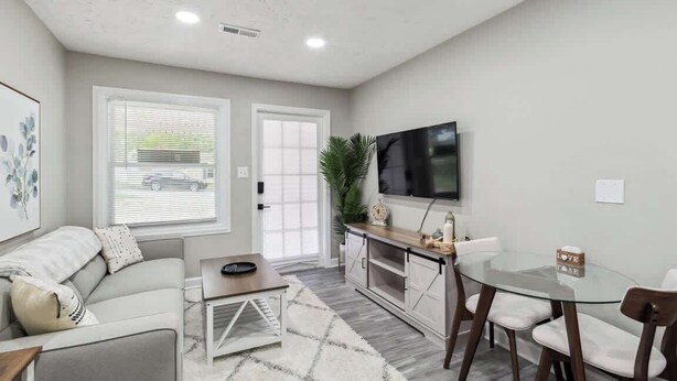Un salon moderne comprenant un canapé, une table basse, un téléviseur et un coin repas.