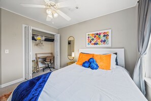 A bedroom with a bed, a desk, and a ceiling fan. - Beautiful retreat. Kid, bike, dog & work friendly. Pool, ping-pong & foosball! (Bentonville)