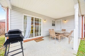 A covered patio with a grill, dining table, and chairs. - Beautiful retreat. Kid, bike, dog & work friendly. Pool, ping-pong & foosball! (Bentonville)