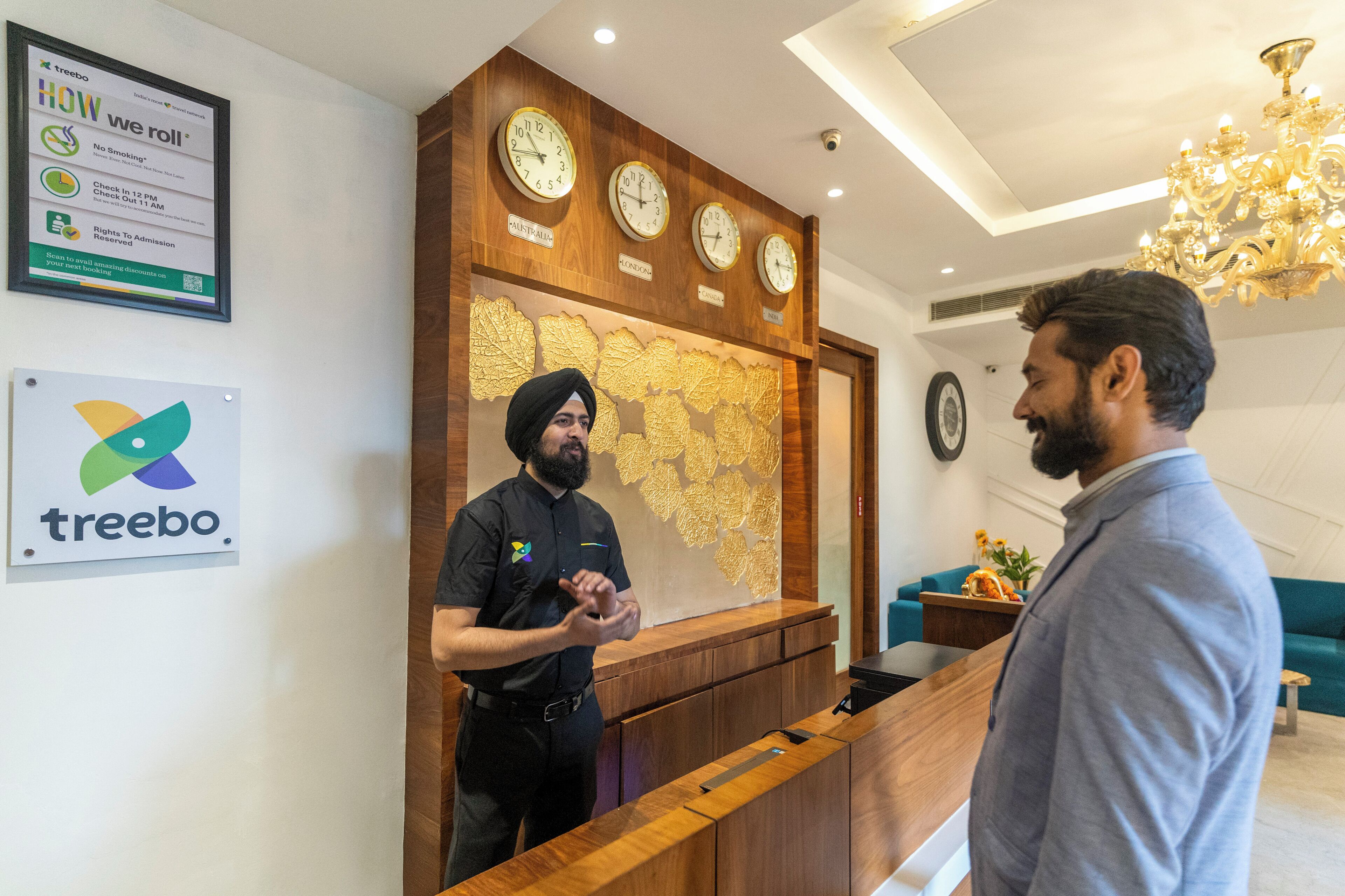 A reception area with a wooden counter, clocks, and a map on the wall.