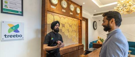 A reception area with a wooden counter, clocks, and a map on the wall.
