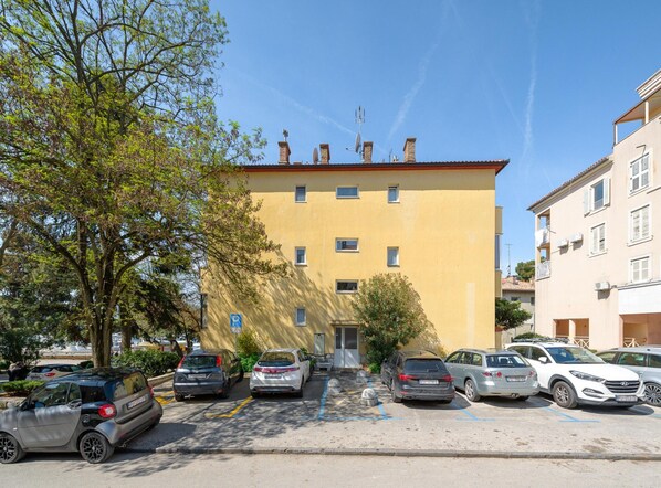 Stylish residential building with a red-tiled roof and parking.