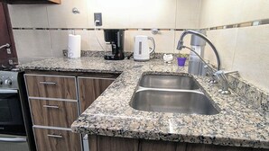 A kitchen with granite countertops, stainless steel sink, stove, and cabinets. - A lo de Pepa - Full house, temporary family rental, in the Uco Valley (Tupungato)