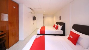 A hotel room with two beds, a wardrobe, an air conditioning unit, and a television. - Aira Hotel Melaka (Malacca City)