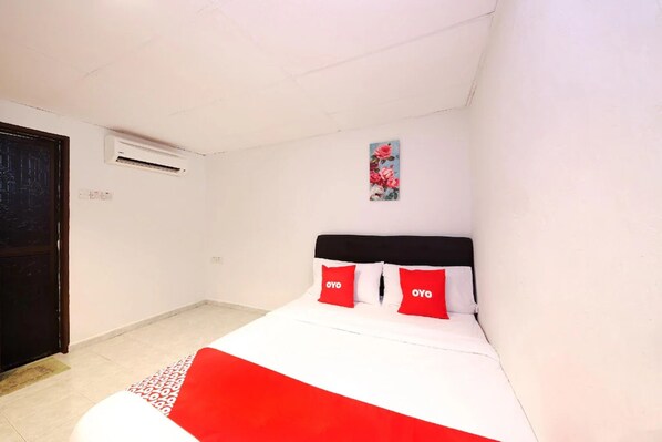 A small, clean room with a bed, a door, and an air conditioning unit on the wall. - Aira Hotel Melaka (Malacca City)