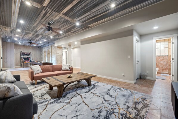 Un salon spacieux avec un canapé, une table basse et un ventilateur de plafond.