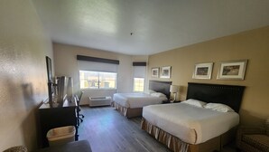 A hotel room with two beds, a desk, a chair, and a window. - CASH REWARDS INN & SUITES (Roswell)