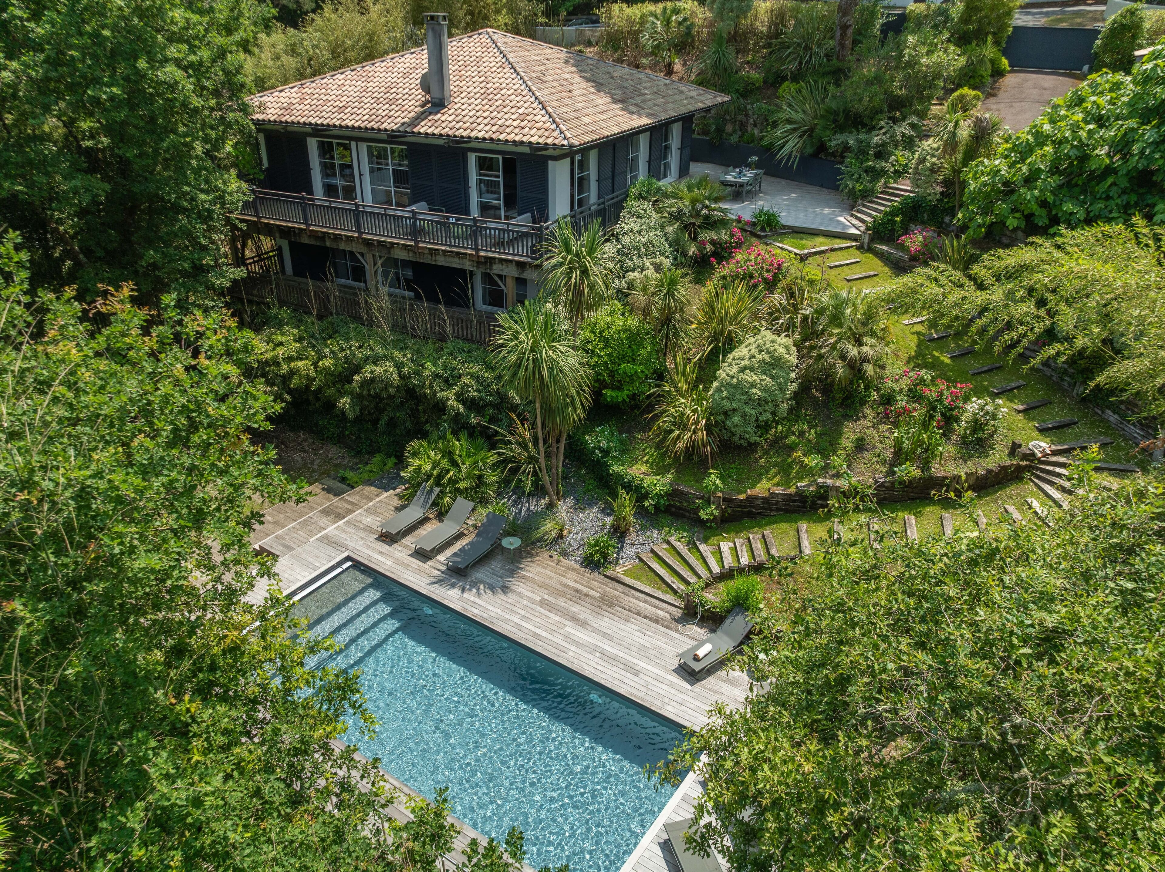 A two-story house with a pool and a deck.