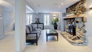 Un amplio salón con chimenea de piedra, un sofá y una mesita de centro.