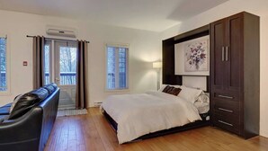 A bedroom with a bed, a desk, a chair, and a wardrobe.