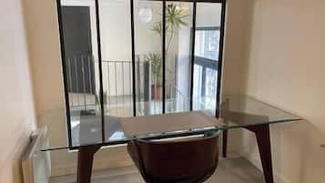 A modern room with a glass table and dark wooden chair.