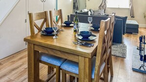 A dining area with a wooden table set for four, surrounded by chairs. - 2 bedroom accommodation in Beverley (Beverley)